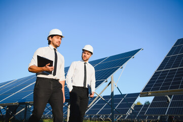 Portrait of engineers standing outside near solar panels