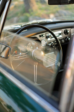 Driver's side of a classic car shot behind window
