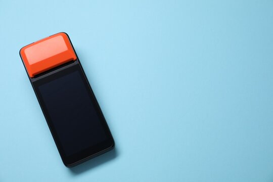 One payment terminal on light blue background, top view. Space for text