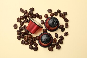 Coffee capsules and beans on beige background, flat lay