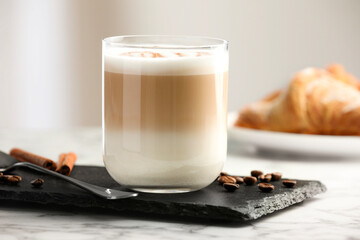 Tasty latte macchiato in glass on marble table, closeup. Coffee drink