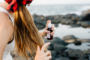 Woman spraying a texturizing hair spray over her hairstyle