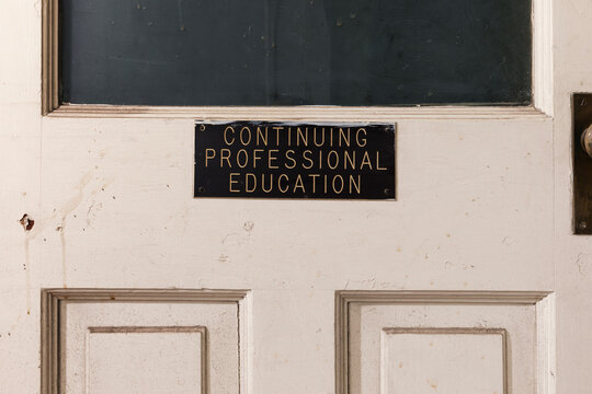 Sign that says "CONTINUING PROFESSIONAL EDUCATION" on a dusty door