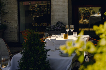 Table setup on a sunny terrace with glasses and tableware 