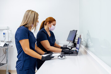 Healthcare professionals using laptops in a clinical setting