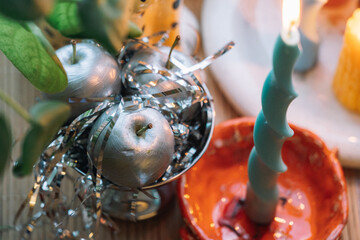 Decorative centerpiece featuring silver apples and colorful candles