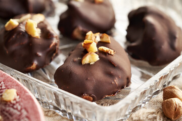 Homemade healthy sweets made of greek yogurt, nut butter and maple syrup coated in chocolate and sprinkled with hazelnuts