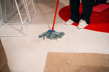 Person Cleaning Floor with Mop in Indoor Setting

