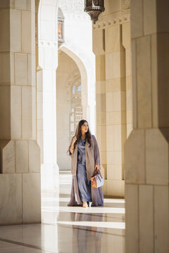 Elegant omani woman walking in sultan qaboos grand mosque