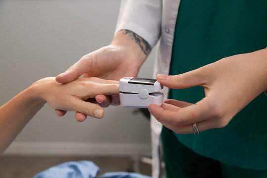 Doctor measuring patient's blood oxygen saturation pulse oximeter