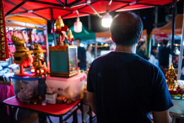 Back View of a Traditional Thai Sacred Mask Artisan in Night Market