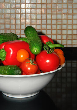 Bowl with fresh vegetables on a kitchen countertop. 