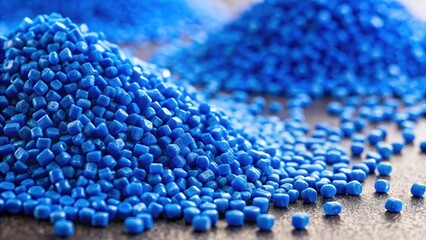 Fototapeta premium Close-up of two stacks of blue polypropylene granules on a table, with some individual particles scattered around, showing their texture and color variation , plastic material, polypropylene granules