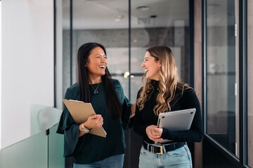 Cheerful coworkers discussing in hallway