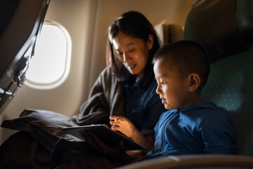 Mother and child using a tablet on an airplane