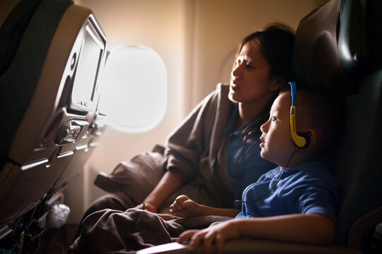 Mother and Child Enjoying In-Flight Entertainment on Airplane Jo
