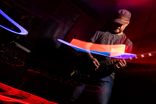 Guitarist Performing with Vibrant Light Trails on Stage