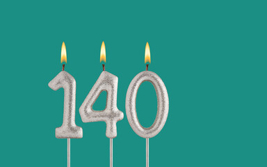 Birthday candle number 140 - Card on a green background.