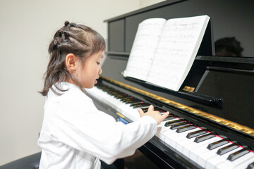 A 6-year-old Japanese girl is playing the piano at home. © Masakazu Tokashiki