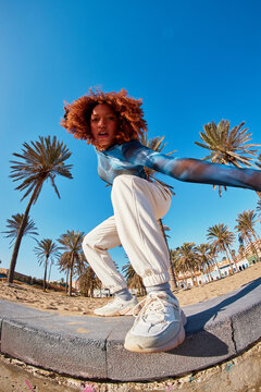 Stylish black woman dancing confident on stone border