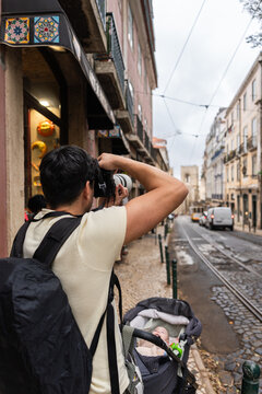 Tourist taking photos in lisbon with baby stroller