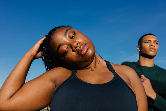 Plus size woman passing time with friends while practicing flexibility