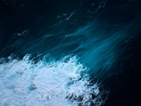 Top down aerial view of moody blue ocean wave
