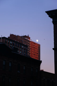 Moon over city buildings