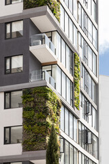 Apartments featuring vertical gardens, blending nature with urban living. The lush green plants...