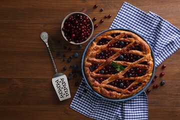 Delicious currant pie with fresh berries on wooden table, flat lay