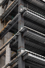 Naklejka premium A multi-level parking garage viewed from the ground, showcasing its structured design. The towering building is filled with cars, with a clear view of the parking levels and ramps leading upwards.