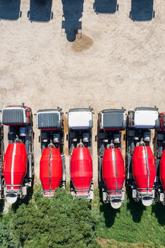 Aerial view of parked red cement mixer trucks in a row