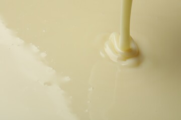 Pouring delicious condensed milk as background, closeup