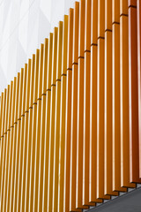 Orange metal structure in the form of bars, creating a striking and bold design that adds a modern and dynamic touch to the space.