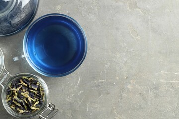 Delicious butterfly pea flower tea on gray textured table, flat lay. Space for text