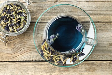 Delicious butterfly pea flower tea on wooden table, flat lay