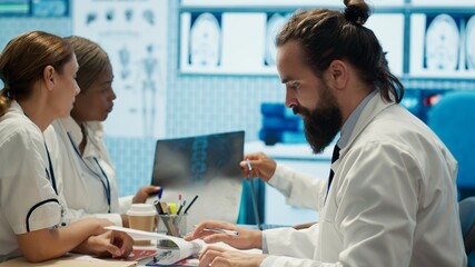 Fototapeta premium Medical professionals analyzing anatomy x ray scans to find the best treatment, research meeting. Teamwork and expertise in radiology and diagnostics ensure recovery on insurance. Camera A.