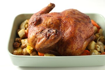 Delicious baked turkey and vegetables in baking dish on white table, closeup