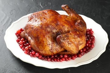 Delicious baked turkey and cranberries on dark gray textured table, closeup