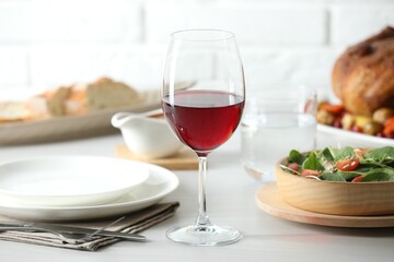 Red wine and delicious dinner served on light table