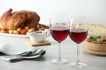 Red wine and delicious dinner served on light table