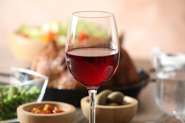 Red wine and delicious dinner served on table, closeup