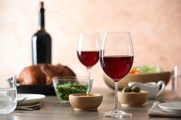 Red wine and delicious dinner served on wooden table