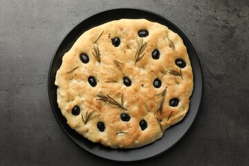 Delicious focaccia bread with olives and rosemary on grey table, top view