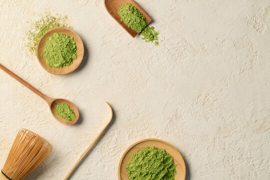 Green matcha powder elegantly presented in a wooden bowls