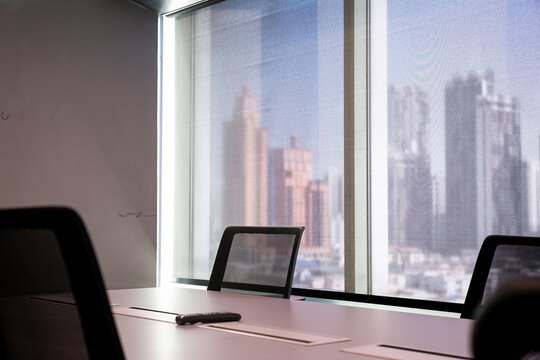 An empty corporate meeting room with the Bangkok cityscape behind it