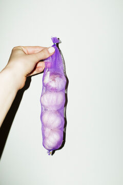 Fresh delicious garlic in purple bag with hard direct flashlight