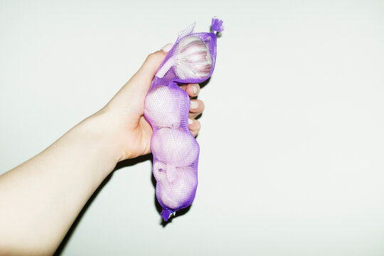 Fresh delicious garlic in purple bag with hard direct flashlight
