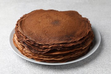 Delicious chocolate crepes on light grey table, closeup