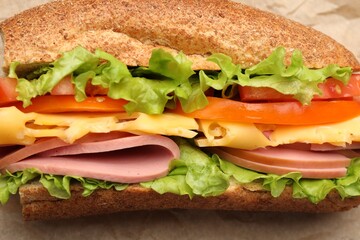 Delicious baguette sandwich on parchment paper, top view